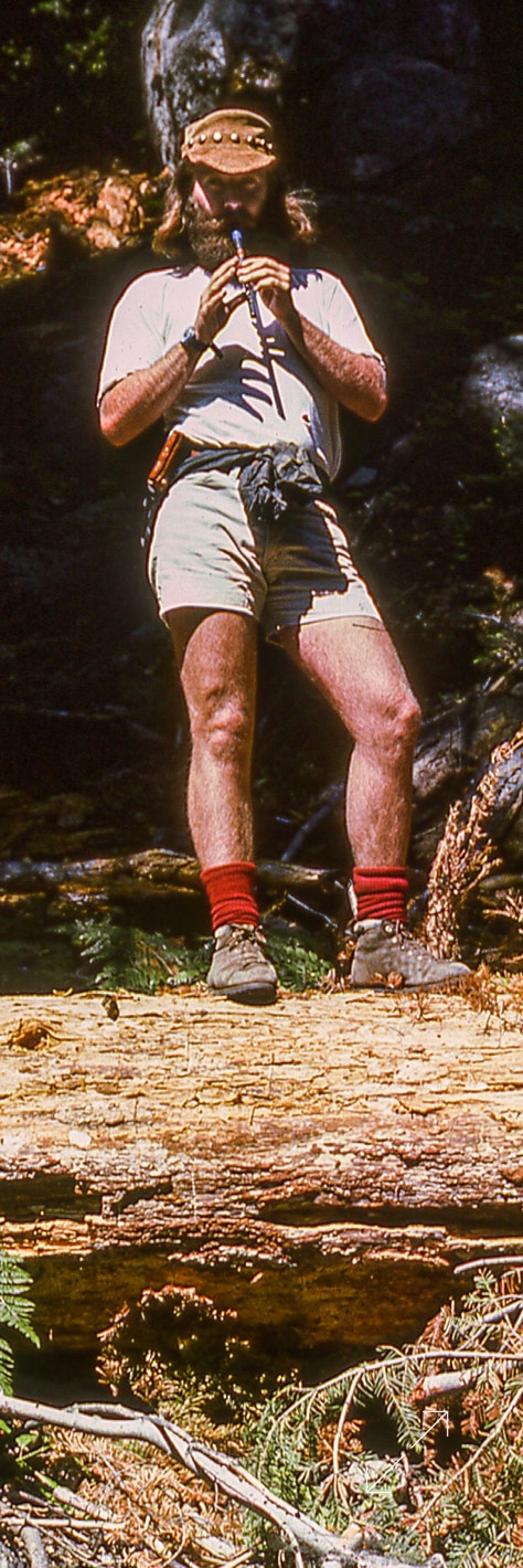 Photo of Ryan Thomson playing pennywhistle in the Sierra mountains in 1978 on a back packing trip with friends.