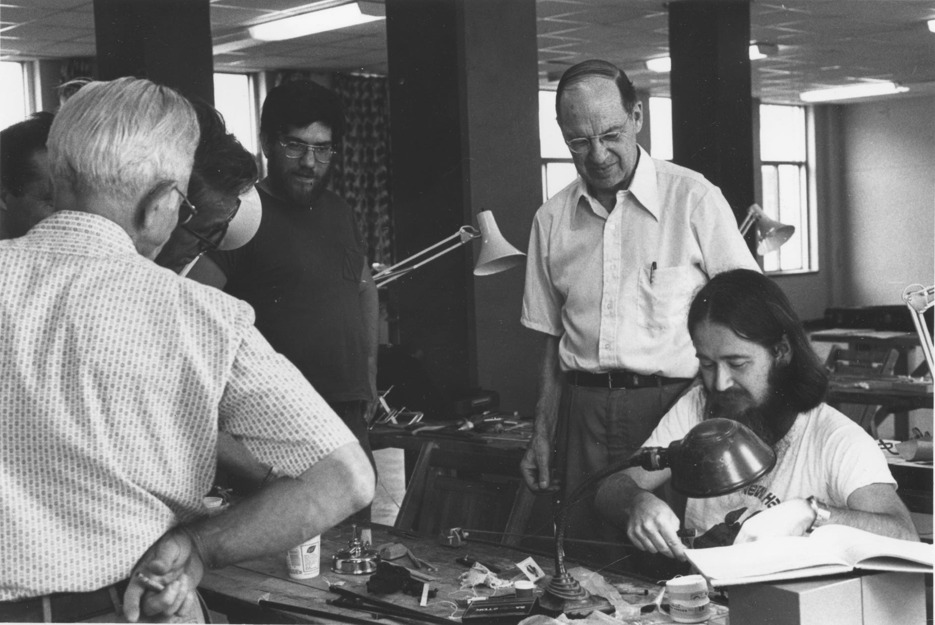 Photo of Arnold Bone instructing Ryan Thomson in violin bow repair in 1982 at the Summer Violin Institute at UNH
