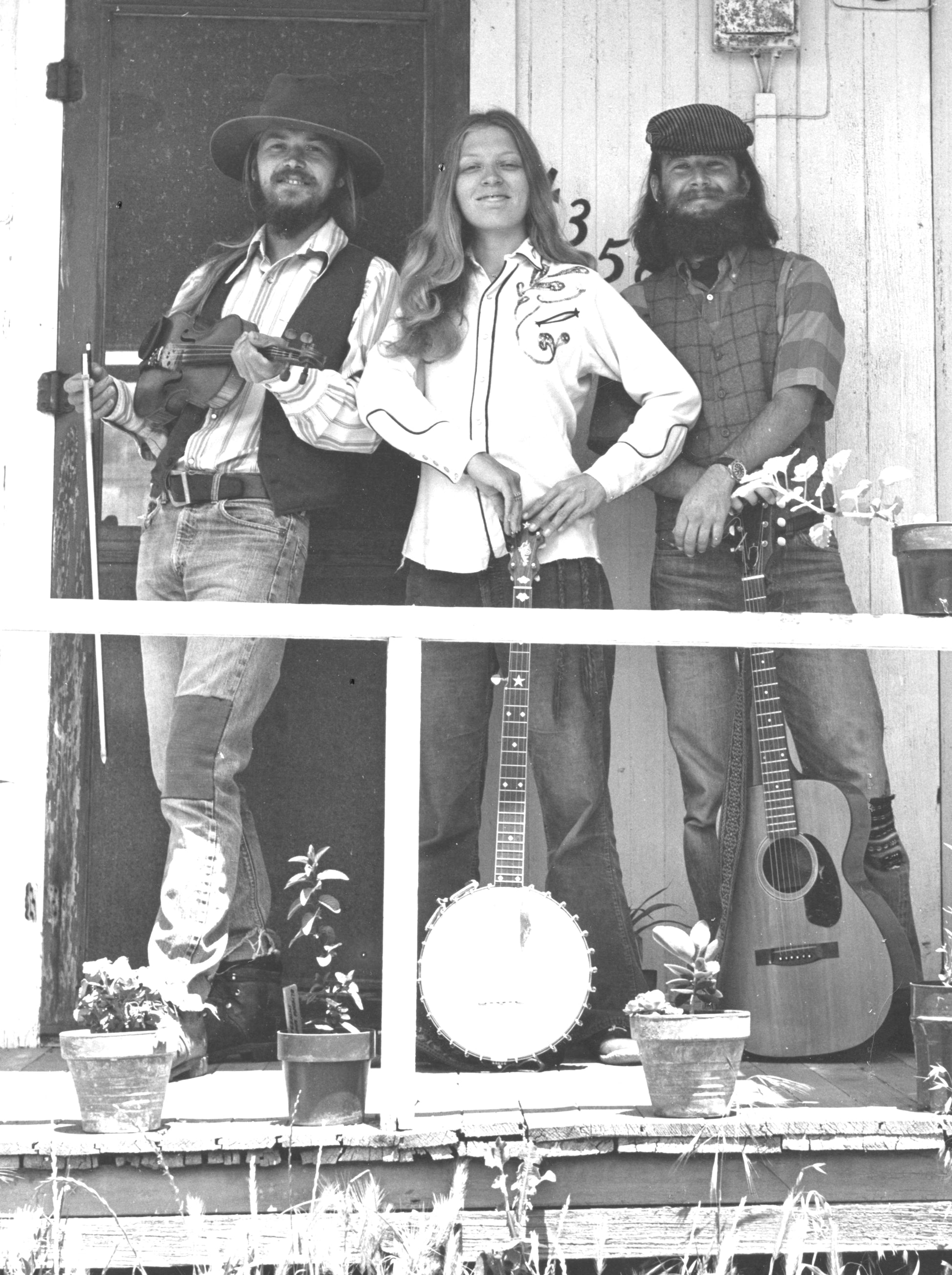 The Chicken Cheek Tweakers old time string band pose on the porch of Pam Ostergren(banjo) and David Brown's(fiddle) cottage in La Mesa, California, Ryan Thomson with guitar, 1974