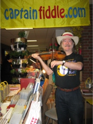 Ryan Thomson running the Captain Fiddle Booth at the New England Folk Festival